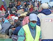 Volontari della Mezza luna rossa tra i profughi ammassati al confine fra Tunisia e Libia (foto Ansa) 